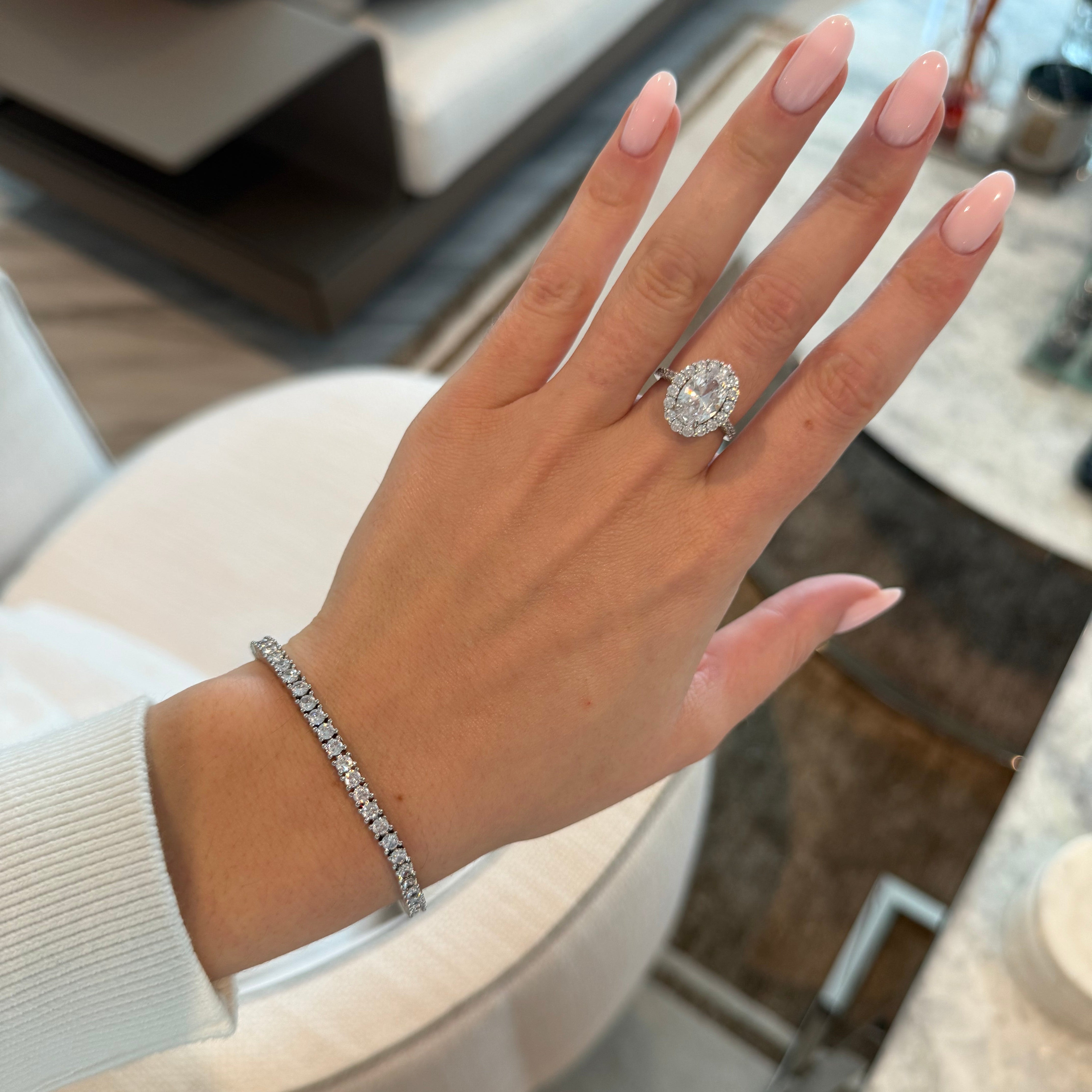 Hand wearing a diamond ring with a blurred background